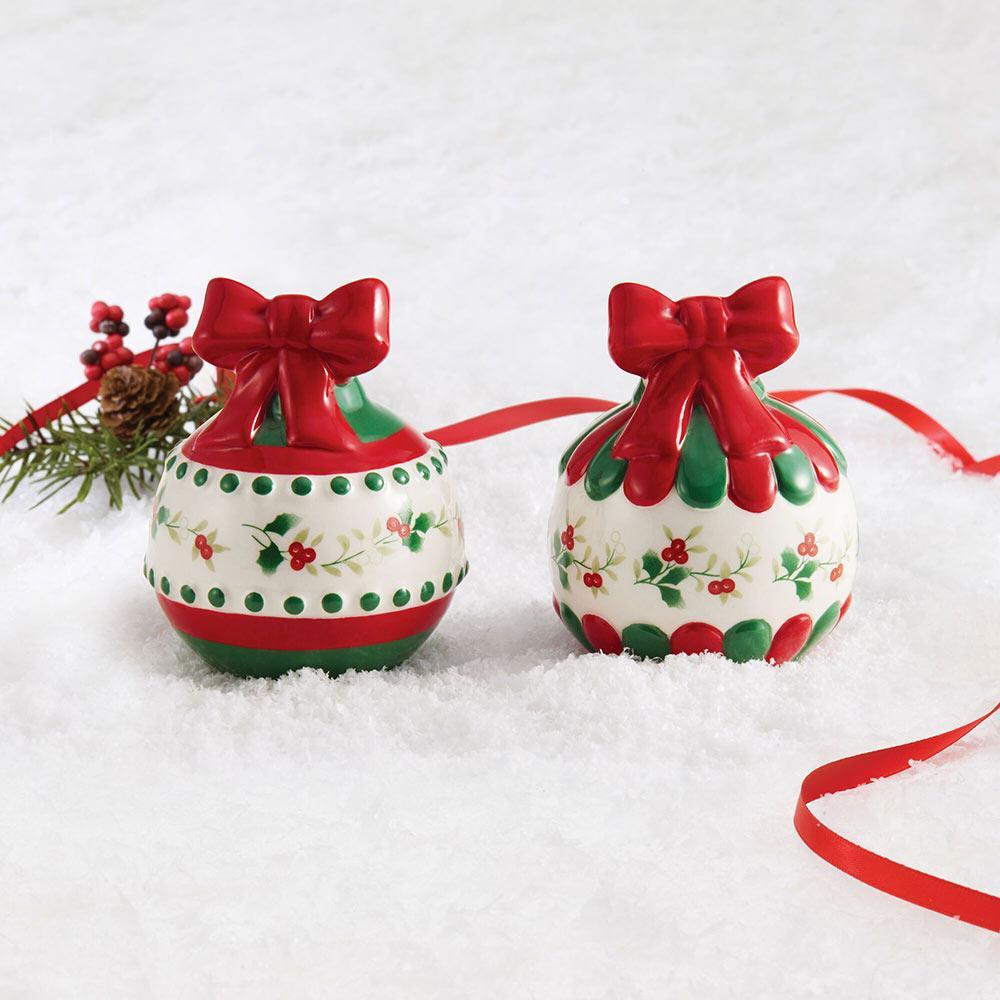 Winterberry ornament salt and pepper set displayed on snow with red ribbon and greenery